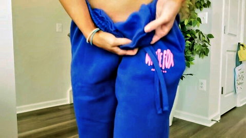 Woman pulling down White Fox Boutique blue sweatpants in sexy try-on haul