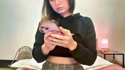 Sundayspreads amateur Chaturbate model in black hoodie and plaid skirt, posing seductively