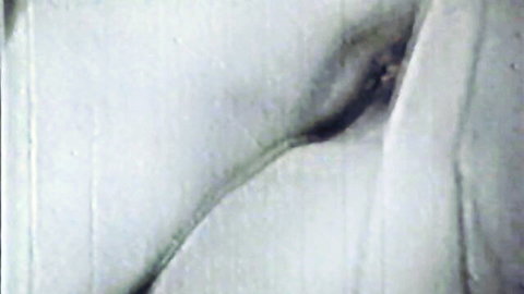 Vintage black and white close-up of nude woman exposing genitals in Cover Girl stag film