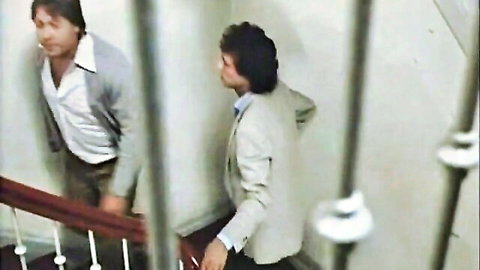 Two suited men in intimate moment on stairs, classic gay porn teaser