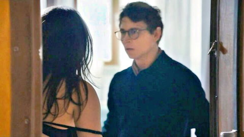 Marie Gillain in low-cut black dress, sideboob exposed, intimate talk with man
