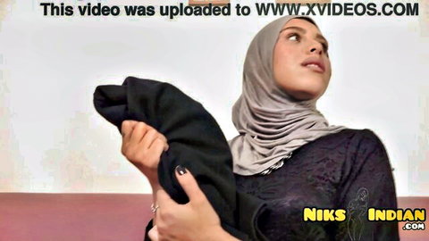 Seductive Muslim hijabi in black lace dress holding fabric tease