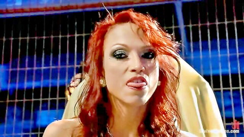 Seductive redhead femdom mistress sticks out wet tongue in teasing domination pose