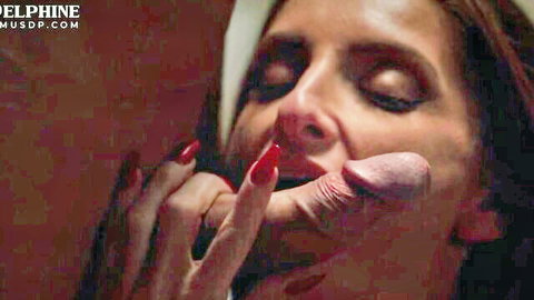 Seductive brunette woman with red nails teases cock near her lips in close-up