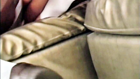 Close-up of shiny beige satin couch armrest and cushions in steamy fuck scene