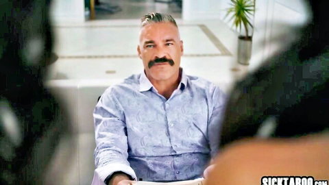 Mature DILF with mustache flanked by two sexy brunettes teasing threesome on couch