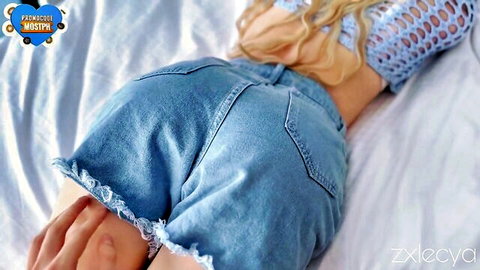Blonde beauty in tight denim shorts teasing her perfect ass on bed