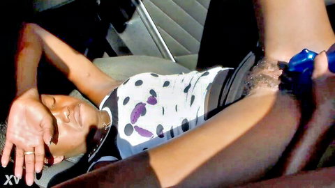Ebony babe lies back in car seat with blue vibrator inserted in wet pussy