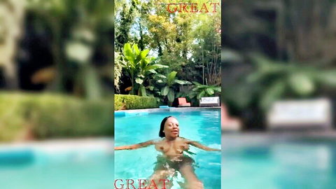 Naked ebony woman floating topless in pool exposing wet tits and body
