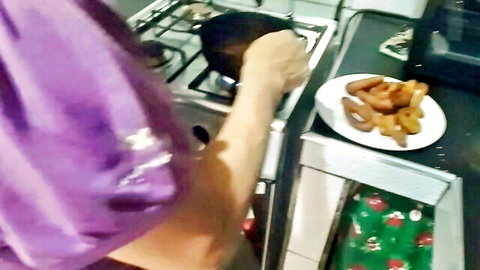 Hijab woman cooking sausages and mandocas in kitchen