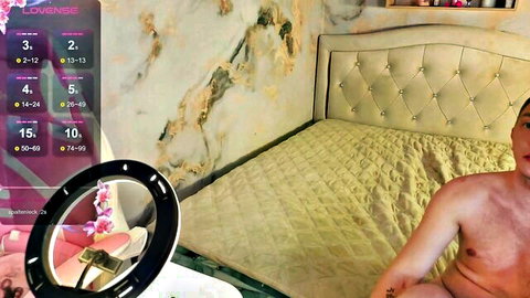 Muscular young guy sits on bed with erect cock exposed during live webcam show