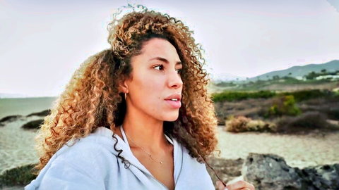 Curly-haired muscle mommy in hoodie, outdoor LA profile view