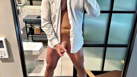 Businessman stroking his huge cock in bathroom mirror solo