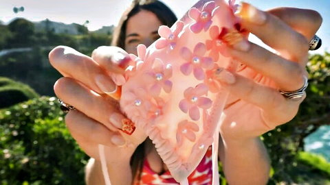 Victoria Xavier trying on pink floral bikini bottoms outdoors