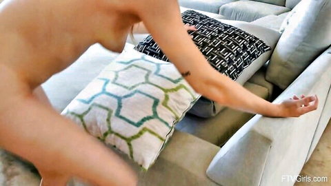 Nude Audrey with large breasts and tattooed arm on couch