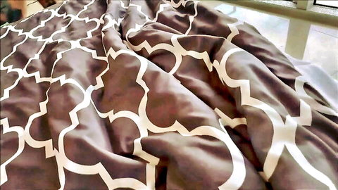 Rumpled patterned bed sheets in sunlit room, teasing risky taboo encounter