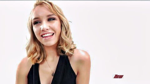 Aurora Belle smiles seductively in low-cut black dress, blonde siren tease