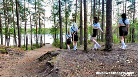 Four young women in schoolgirl uniforms pose outdoors by lake in lesbian tease