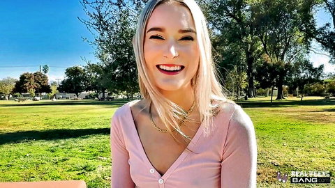 Blonde Thea Summers smiling in pink top outdoors in park