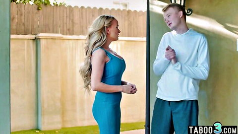 Blonde MILF in tight blue dress talks to young freckled guy at backyard gate