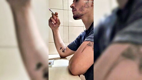 Super sexy muscular guy with tattoos smoking after workout