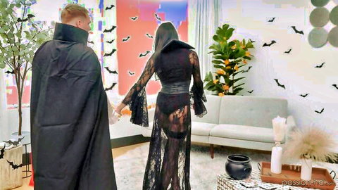 Sexy Halloween vampire couple in sheer black lace gown and cape