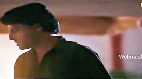 Handsome Indian man in profile, intense gaze, black shirt, Ullu web series scene