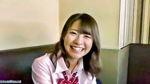 Cute smiling Japanese schoolgirl babe in tight uniform blouse smiling seductively