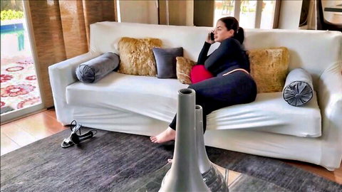 Lissa Aires in black leggings and red top, lounging seductively on couch