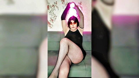 Daring crossdressing alternative look in black dress, fishnets, and glowing orb pose