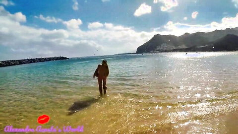 Pretty trans girl in bikini walking into ocean at sunny beach