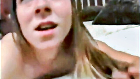 Young Caucasian woman lying topless on bed, long blonde hair, open mouth aroused