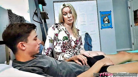 Blonde stepmom in floral dress fondles young stepson on bed