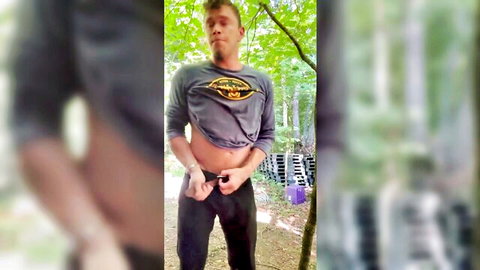 Young white guy in forest unbuttoning pants, teasing cock exposure in piss fetish video