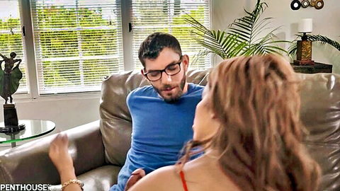 Brunette woman seducing man in glasses on couch in casual encounter