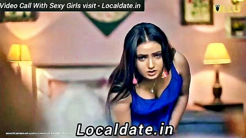 Seductive Indian bhabhi in low-cut blue dress showing deep cleavage