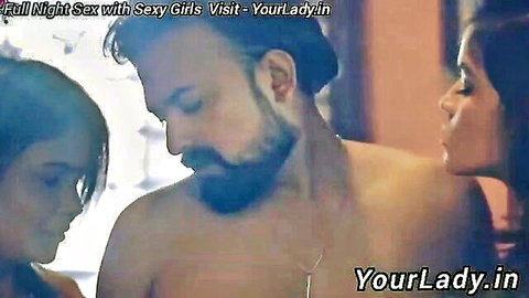 Bearded Indian man in steamy threesome foreplay with two sexy women