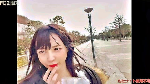 Asian woman in white fur coat teasing with red lips outdoors