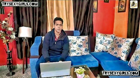 Indian man in hoodie on couch with laptop, teasing maid sex scene
