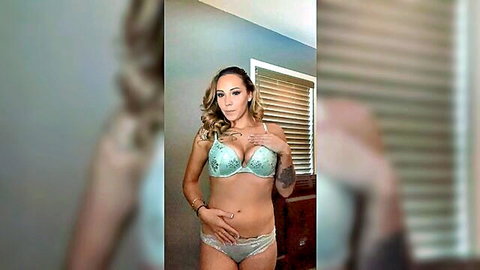 Tattooed brunette in teal lingerie cups her huge tits teasingly