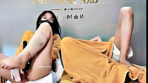 Two sexy Asian girls spreading legs to show pussies in teasing display