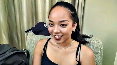 Smiling Asian woman in black tank top, casual solo pose
