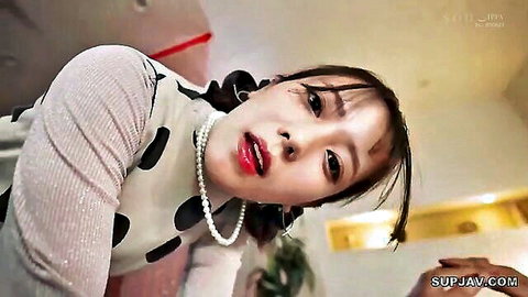 Seductive Asian JAV woman in polka dot top stares intensely at camera, glossy lips