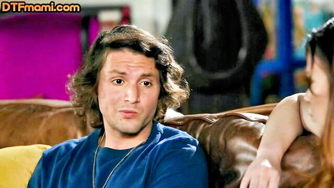 Curly-haired man with brunette MILF on couch in casual encounter
