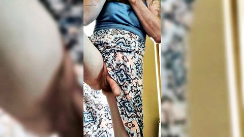 Blurry closeup of woman lifting thigh in patterned pants and blue top