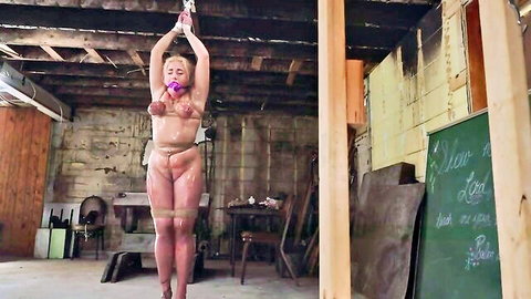 Blonde Zoey nude, ziptied arms suspended, ballgagged in BDSM torment