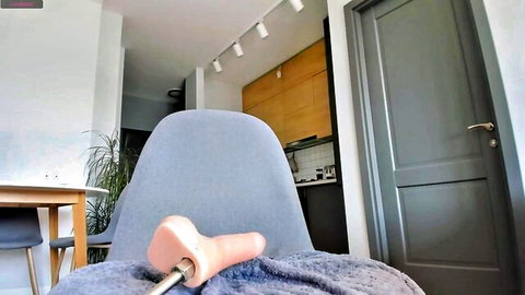 Pink realistic dildo mounted on metal rod atop blue office chair for webcam pussy ride