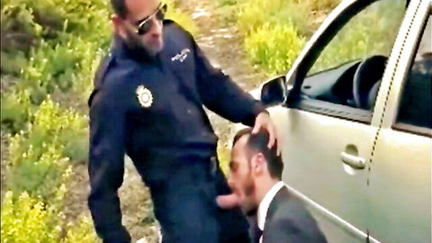 Muscular cop in uniform gets outdoor blowjob from bearded suited man by car