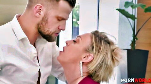 Blonde mature woman passionately kissing muscular bearded man in white shirt