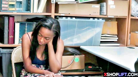 Busty ebony teen in tank top and skirt sitting in office interrogation